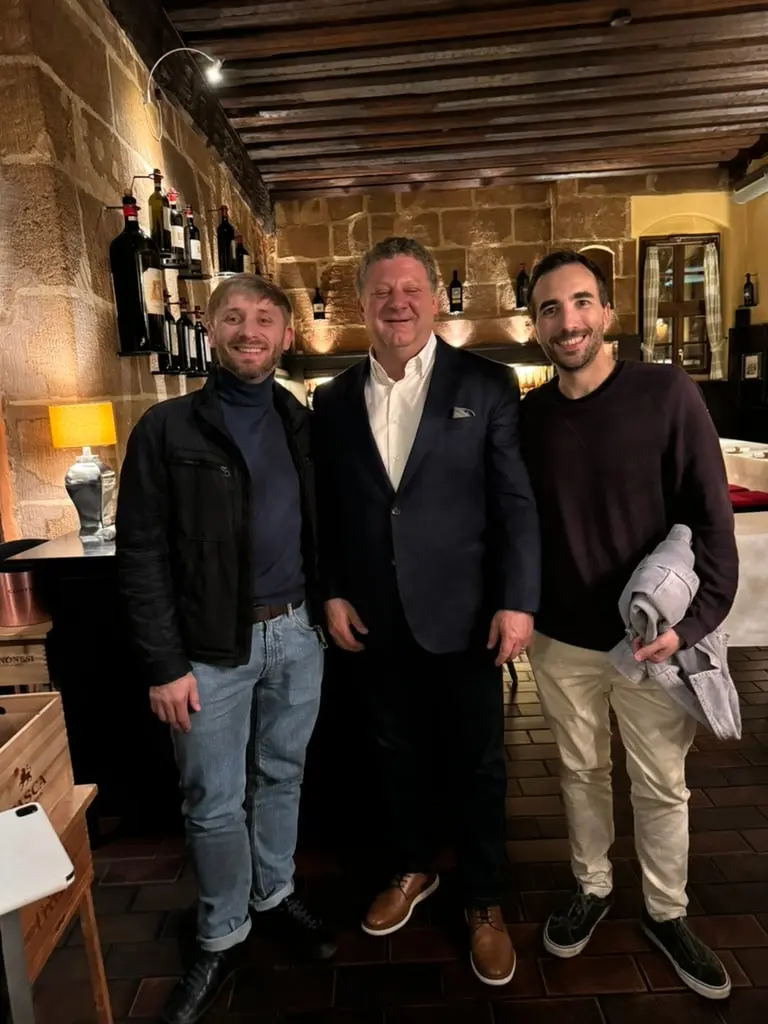 three men standing at a restaurant