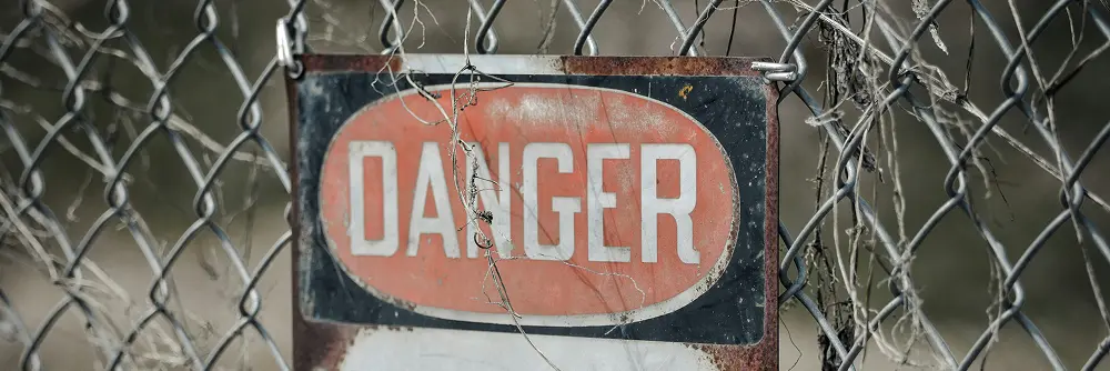 A danger sign is posted in front of barbed wire