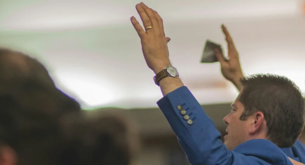 Businessman raising his hand to ask a question during a conference