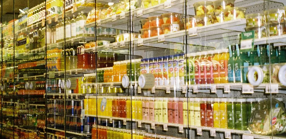 Close-up of refrigerants in a supermarket containing juice bottles.