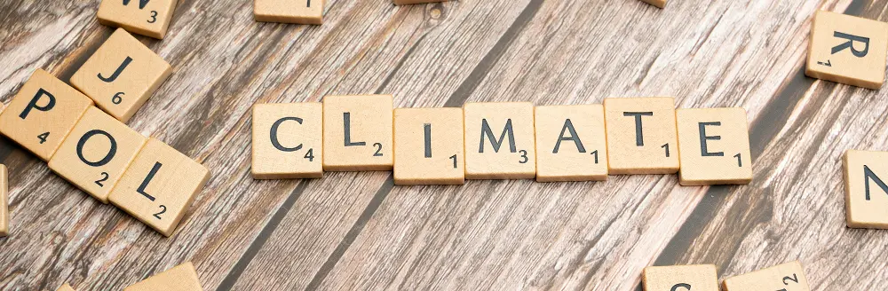 Scrabble letter tiles arranged on a table forming the word climate