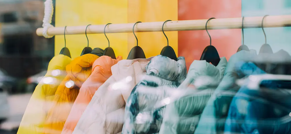 Jackets in various colors hanging on hangers, evoking a retail display.