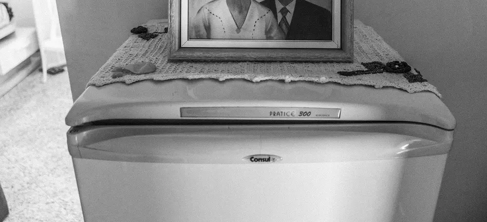Old vintage refrigerator with a framed photograph of a couple