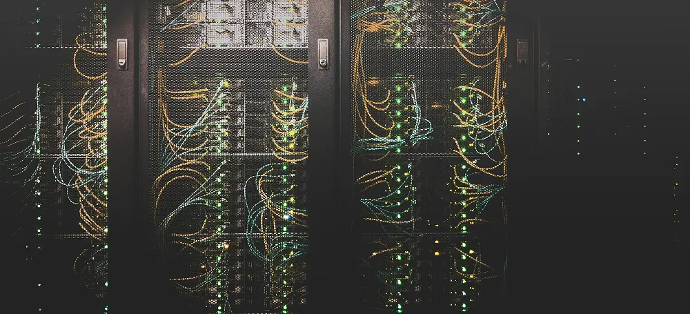 Close-up of a data center cabinet with orange and blue cables and green indicator lights