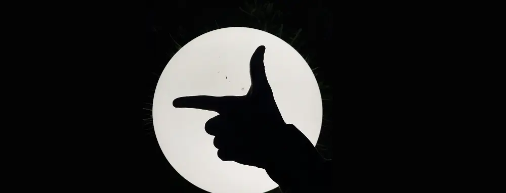 Silhouette of a hand making the shape of a gun in shadow