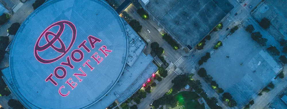 Aerial view of the Toyota Center with its red logo, surrounded by city buildings