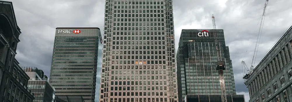 Three bank buildings, including Citi and HSBC, in a cloudy cityscape