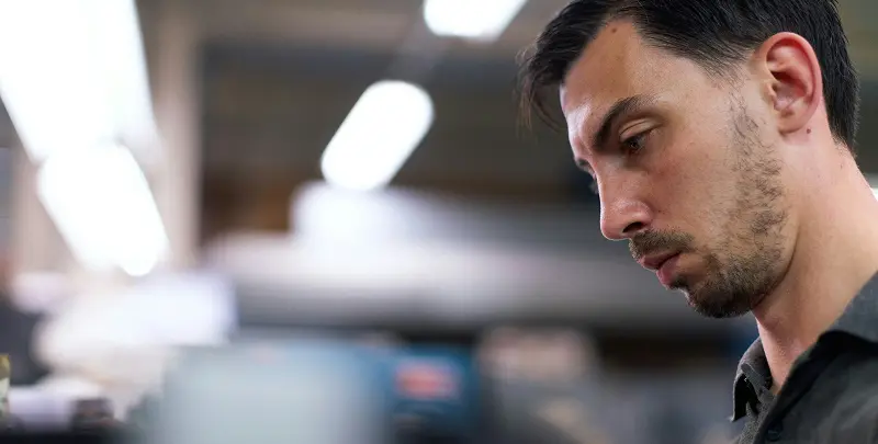 A focused HVAC male technician working with deep concentration